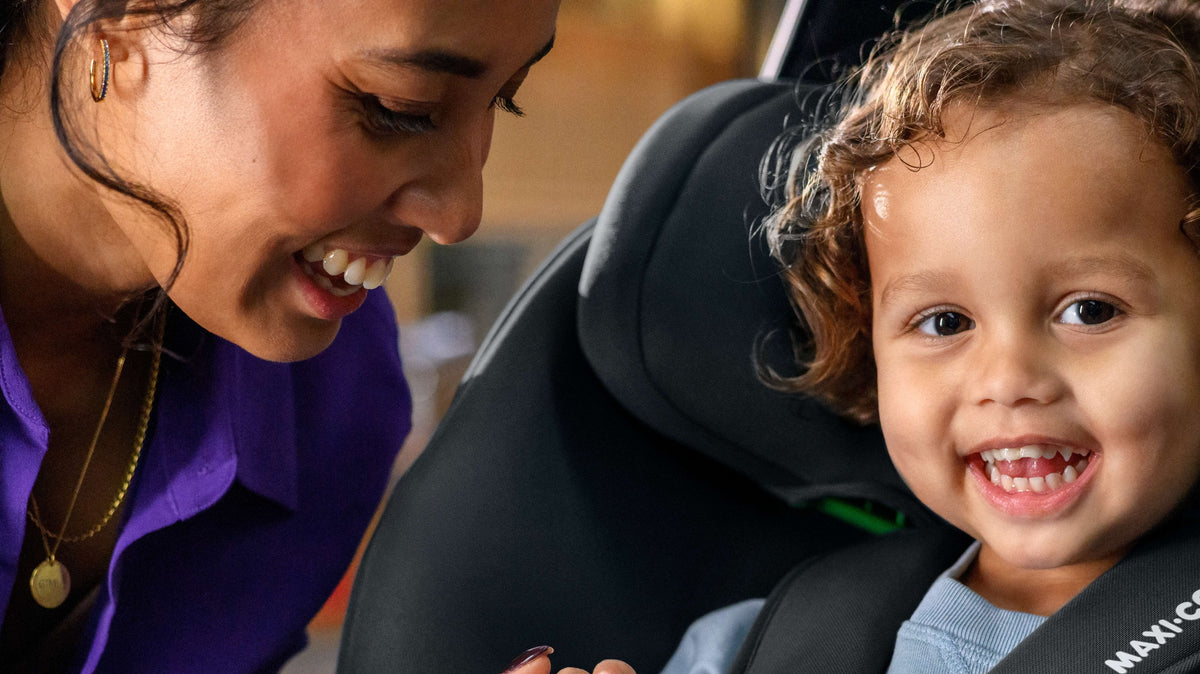 mother smiling at child in car seat