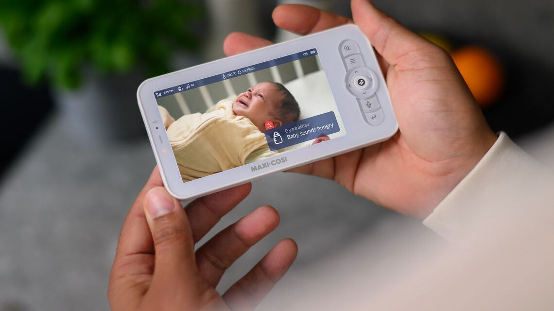 Parent looking at baby monitor that says Baby Is Hungry