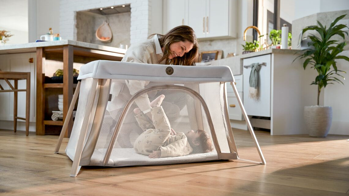 Mom putting baby in play yard