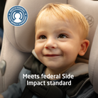 Child in a car seat with a label indicating meeting federal side impact standards.