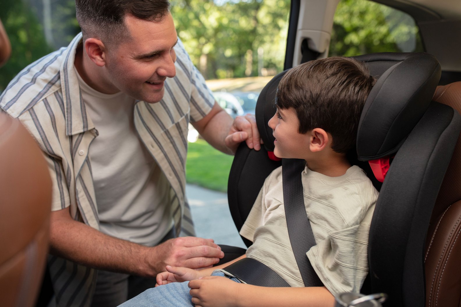 father smiling at son in his RodiSport Booster Car Seat