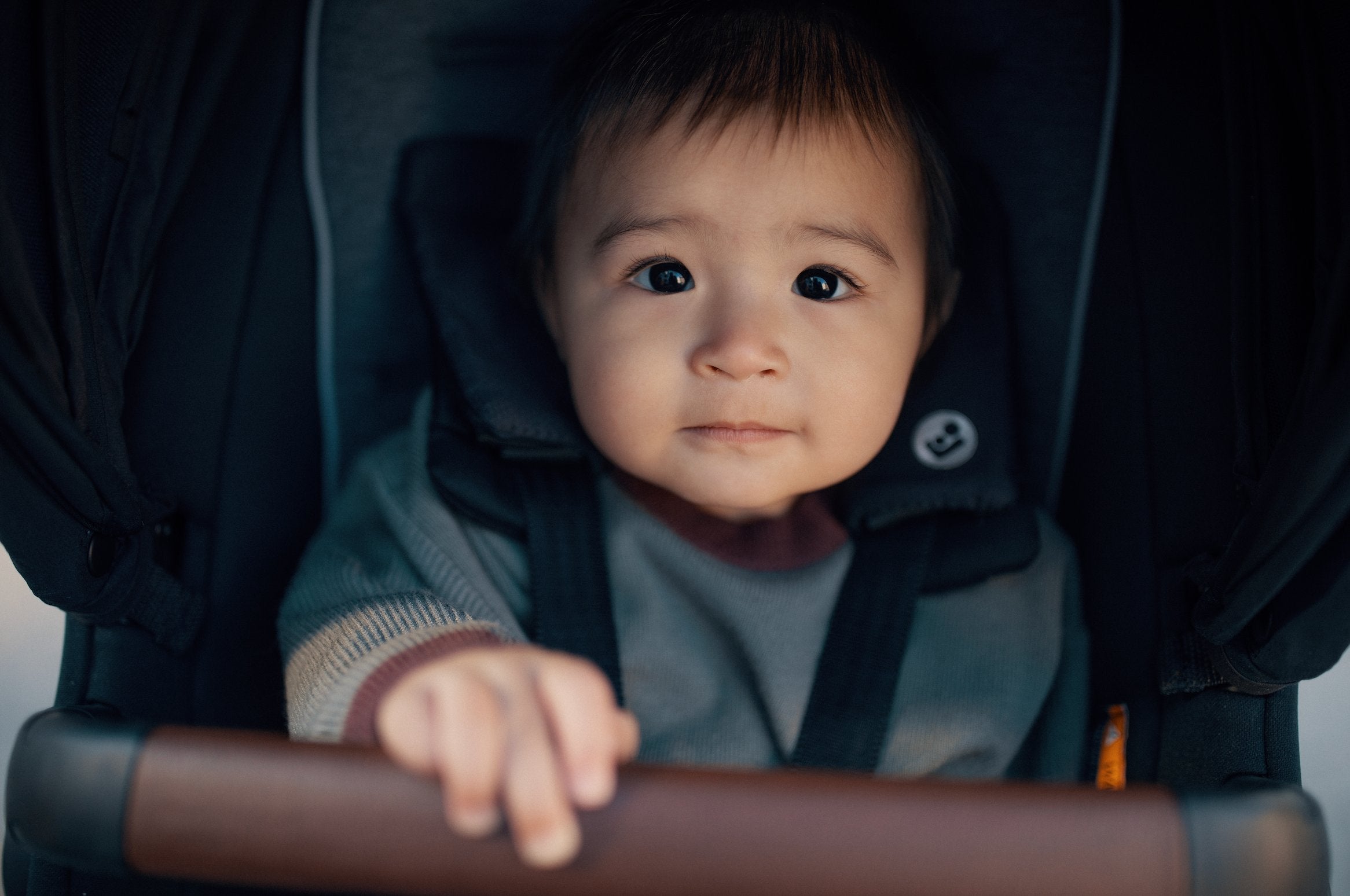 Father holds infant car seat while mother pushes toddler in stroller