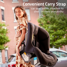 Woman holding a car seat with a convenient carry strap feature, outdoors.