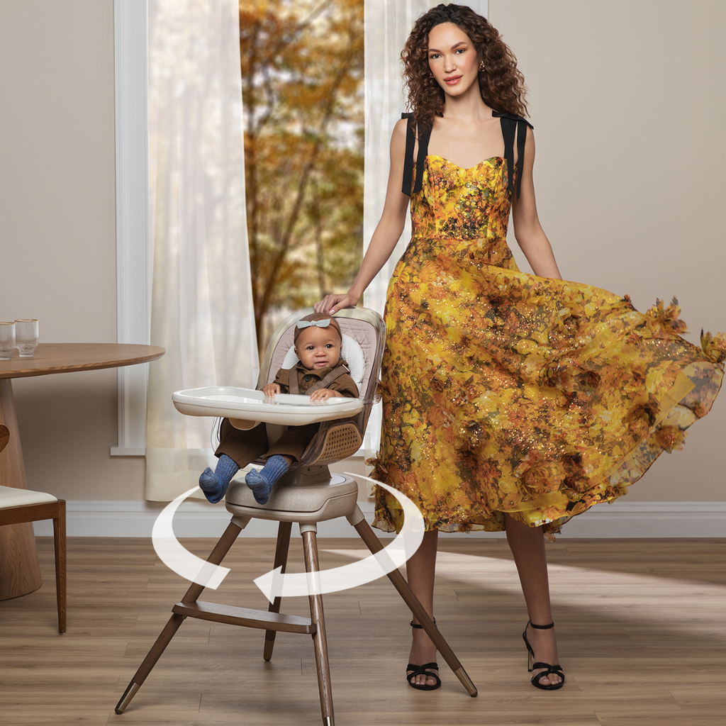 mother standing by child in Kiskadee High Chair with arrow showing how it rotates