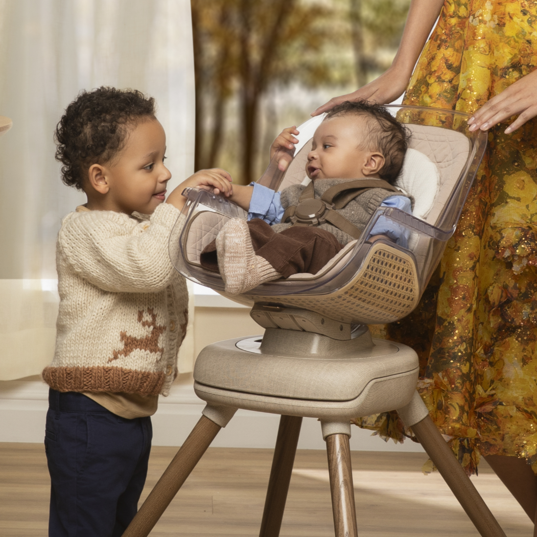 Boy holding hand of toddler in Kiskadee High Chair