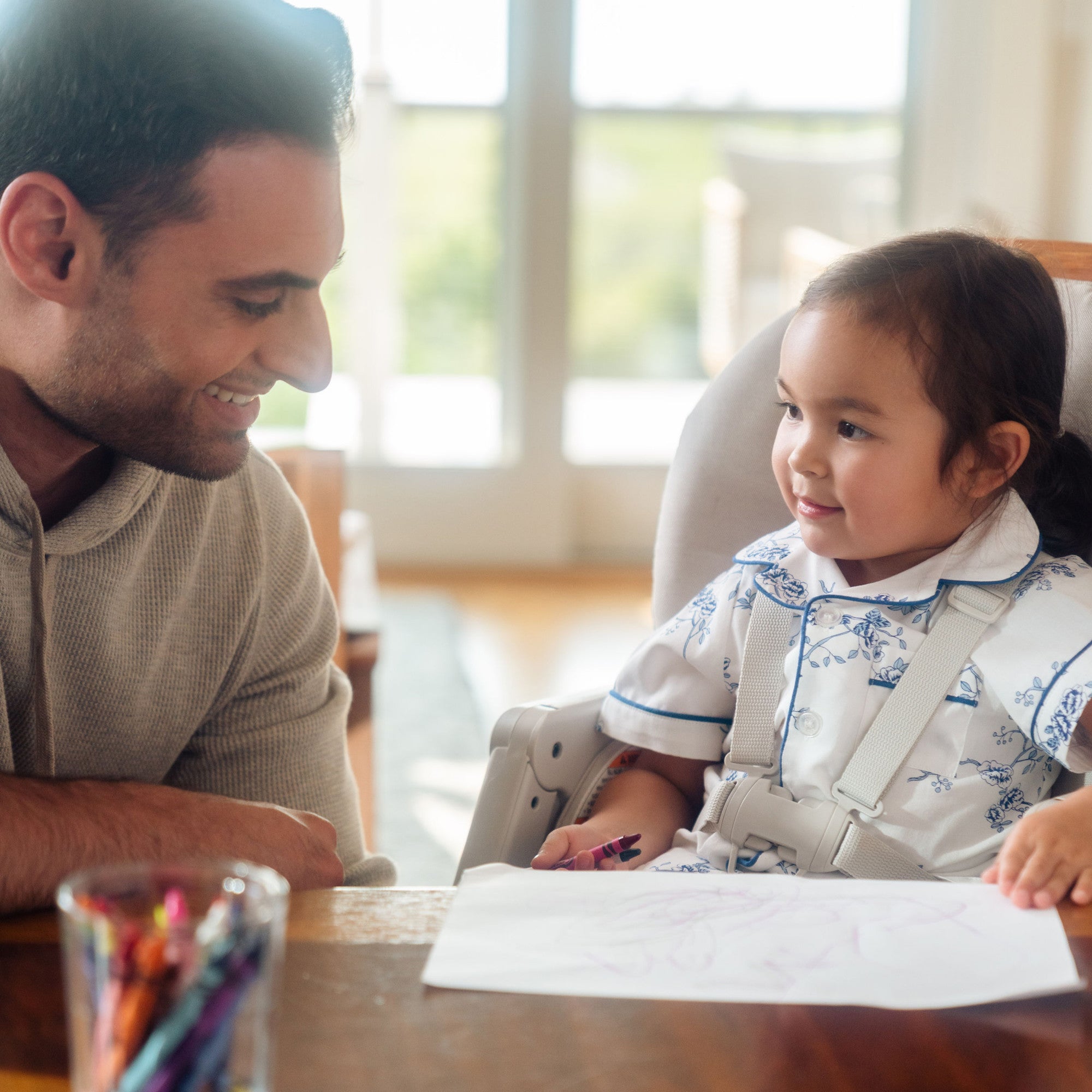 Minla 6-In-1 High Chair - child in high chair drawing with father looking on