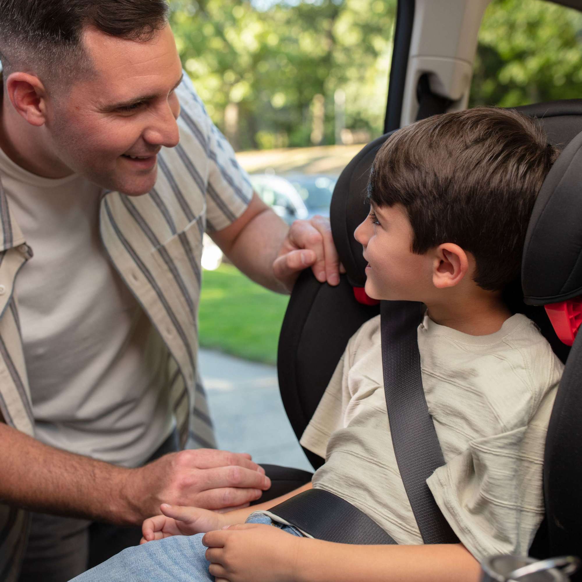 RodiSport Booster Car Seat - dad and child smiling while child sits in car seat