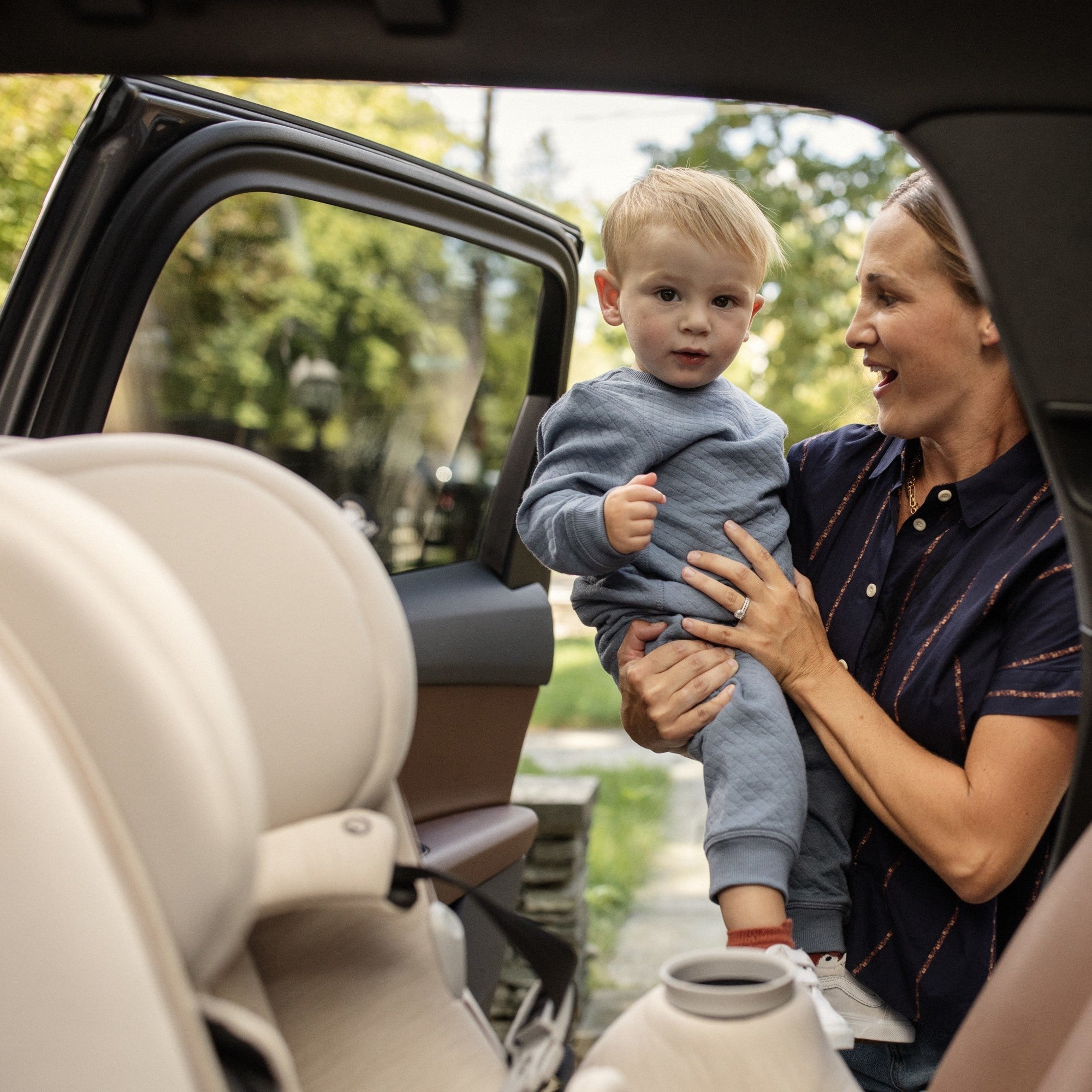 Pria™ Max All-in-One Convertible Car Seat - mother holding toddler son with rear-facing car seat in foreground