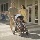 Zelia™² Luxe 5-in-1 Modular Travel System - mother and father walking baby in front-facing stroller mode